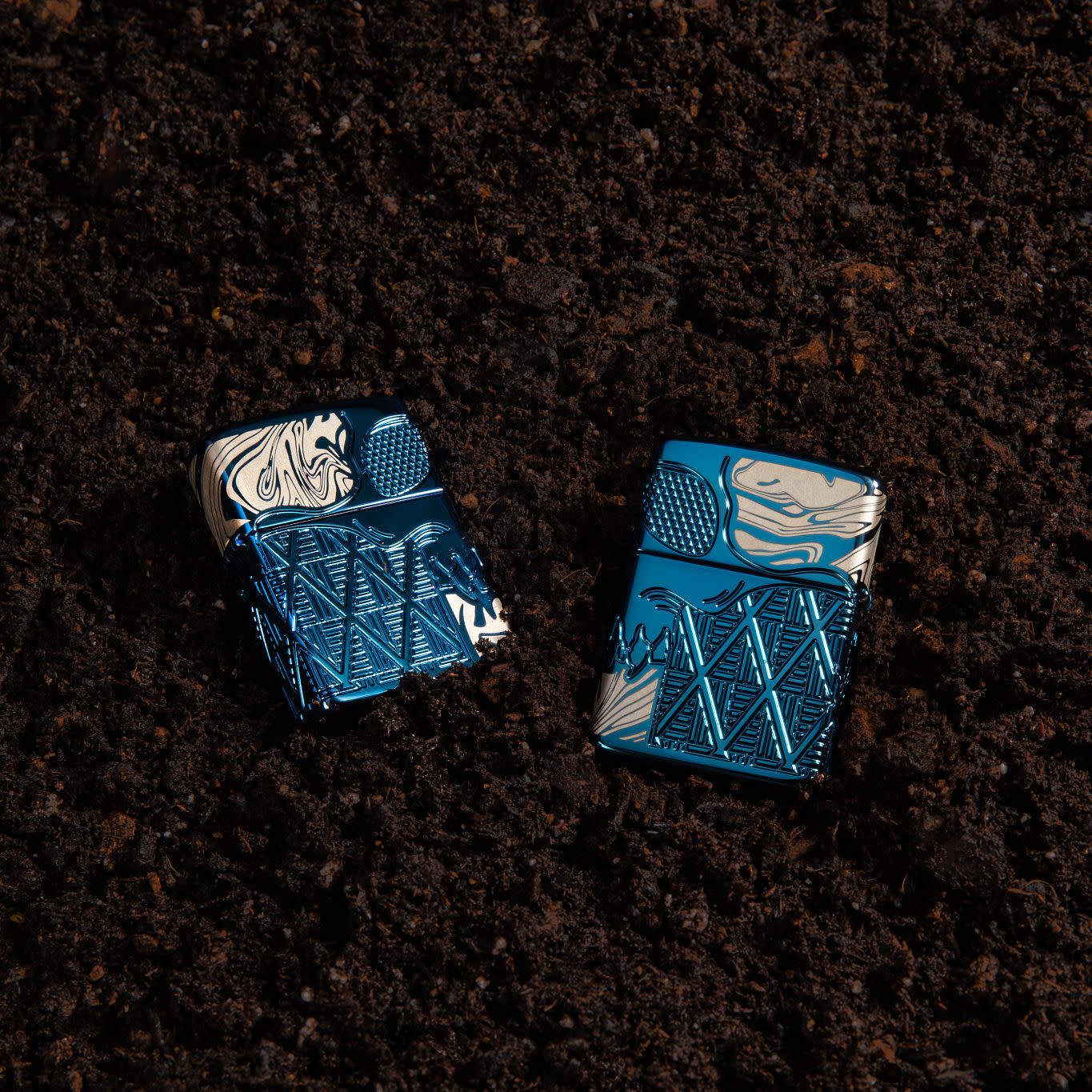 Lifestyle image of Skull Design Armor® High Polish Blue Windproof Lighter laying in the dirt.