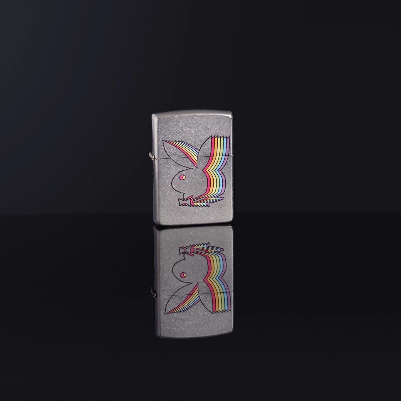 Lifestyle image of Playboy Street Chrome™ Windproof Lighter standing on a black reflective surface