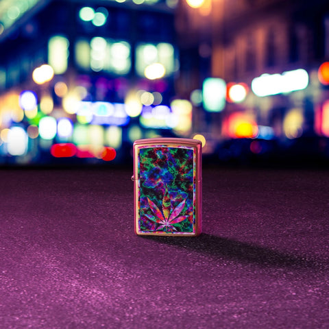 Lifestyle image of Leaf Design Brushed Brass Windproof Lighter standing in the street, with city lights out of focus in the background