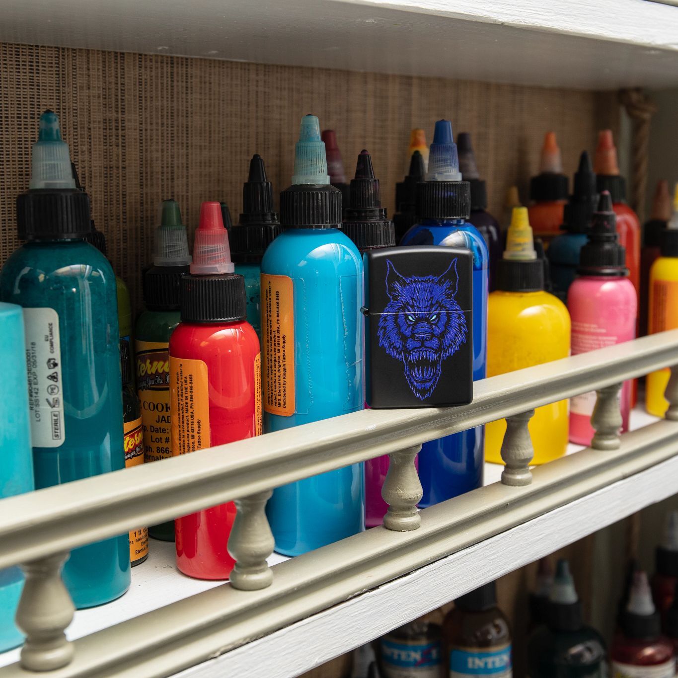 Lifestyle image of Werewolf Design Black Matte Windproof Lighter standing with tattoo ink