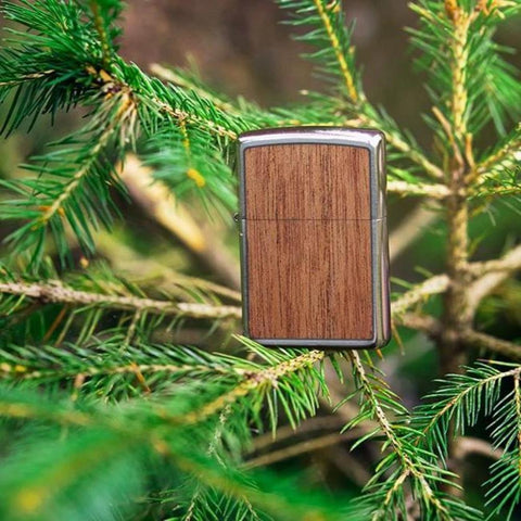 Lifestyle image of WOODCHUCK USA Mahogany Two-Sided Emblem Windproof Lighter in pine tree