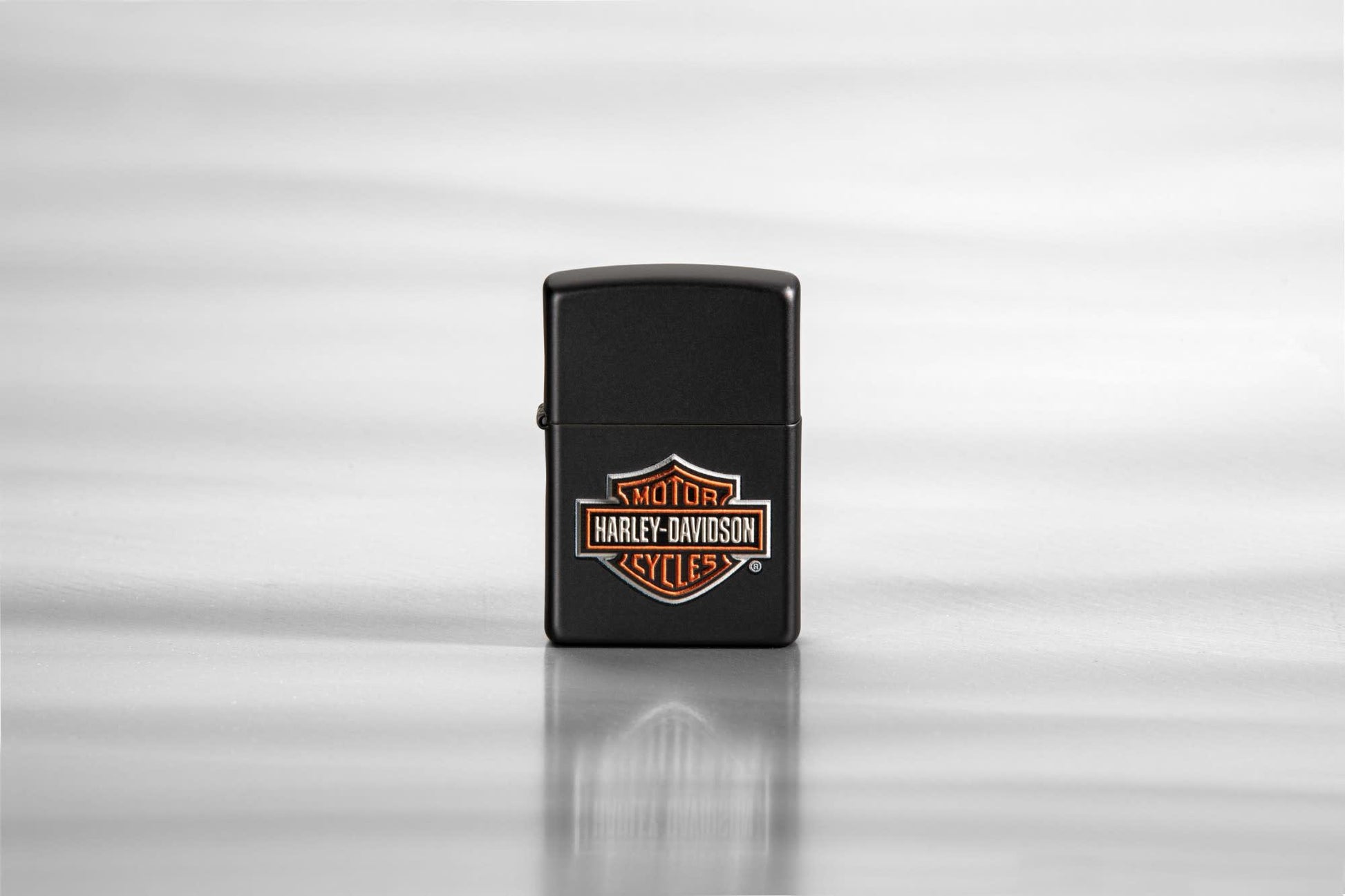 Lifestyle image of Harley-Davidson® Texture Print Classic Logo Black Matte Lighter, standing on a sheet of metal