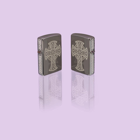 Glamour shot of two Zippo Laser Engraved Celtic Cross Design Black Ice Windproof Lighters, standing in a purple scene.
